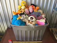Full view of large bin filled with assorted plush toys showing bright colors and character variety