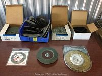 Photo showing various abrasive discs including flap discs, fiber discs and a brass colored wire wheel.