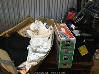 Box containing multiple white shirts, blackout cloth, and other materials for screen printing