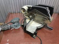 Photo showing Black & Decker Power Miter Saw and orbital sander on a table, cords visible.