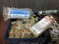 Photo showing multiple epoxy tubes and cartridges including GWT Joint 200 and dual cartridge epoxy tubes with red caps packed in a blue crate.