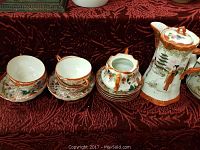 Full view of the antique Asian chocolate pot set with all pieces displayed on a fabric surface