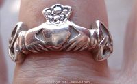 Front view showing the Claddagh design with two hands holding a crowned heart on a person's finger.