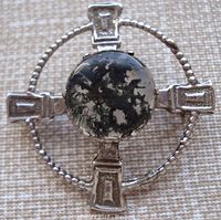 Close-up photo of front of brooch showing the moss agate stone center and Celtic silver design.