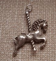 Front view of the sterling silver merry go round horse pendant with detailed horse figure and twisted pole.
