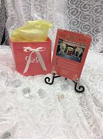 Photo of Starlet box with tissue paper and promotional Starlet card on a clear white fabric background with decorative crystal accents.