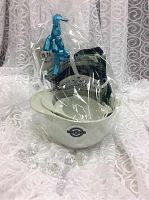 Three white ceramic mixing bowls nested together with Card's Bakery & Goods logo, wrapped in clear cellophane with blue ribbon and visible spatula.