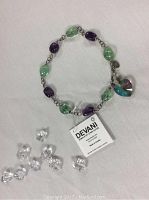 Full view of necklace on white background with loose crystal props and Devani tag visible