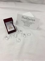 Ring displayed in open presentation box alongside Paul Randolph business card and decorative quartz crystals