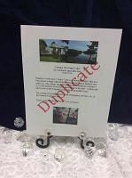 Photo of printed lot information sheet with cottage image and donor watermark