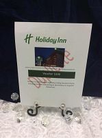 Printed voucher displayed on small black easel on white lace cloth