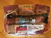 Image shows gift basket contents including six varieties of Wilton cheeses, one large Wilton summer sausage, a pack of Sesmar crackers, and Godfreys Bell Candy humbugs.