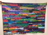 Front view of quilt showing colorful horizontal strips