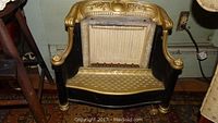 Front view of the antique Humphrey Radiant Fire heater, showing black and gold ornate metal body and interior heating area.
