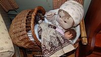 Wicker carriage with two dolls, showing nailed weave and handle.