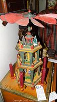 Full view of nativity pyramid showing two tiers, candle holders, and fan blades on top.