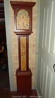 Front view showing full height and design details of the grandmother style clock, including floral painted panel and clock face.