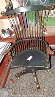 Full front view of the chair showing spindle back, seat and armrests
