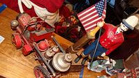 Photo showing the vintage reproduction iron bank with firefighter figurine holding an American flag alongside the reproduction antique toy fire truck.