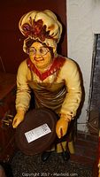 Front view of the Grandma Butler statue showing facial details, bonnet, apron, and tray.