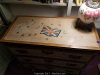 Top of dresser showing hand painted Union Jack-style flag and star and vine motifs