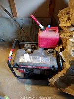 Generator visible with attached red gasoline can on top.