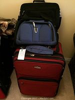 Set of three bags: large red suitcase, medium black carry bag, small blue carry bag stacked.