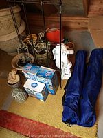 Photo showing ceramic owl, cherub statue, multiple flower pots, metal plant stand, and blue folding chairs in bags.