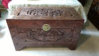 Front and top view of carved wood chest with metal clasp