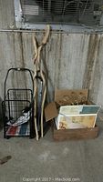 Full lot view showing shopping cart, two wooden walking sticks, wooden crate, and cardboard box containing light fixture parts