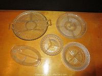 Overview of six glass and crystal serving dishes showing variety of shapes and decorative patterns.