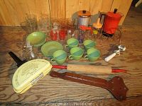 Wide shot of all kitchen items showing details of cups, plates, glasses, percolator, rolling pin, food chopper, key holder, and scoop