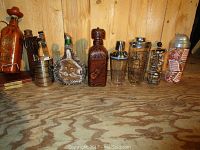 Full view of the bar items including decanters and cocktail shakers on wood surface with pine panel background