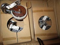 Four new Ikea Besta castors packaged in cardboard boxes, showing one castor partially visible and wrapped with a price label.