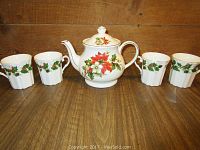 Full set photo showing Sadler tea pot and four Royal Grafton tea cups with Christmas floral pattern on wooden floor