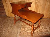 Side view of the maple end table showing the drawer, turned legs, and slanted lower shelf.