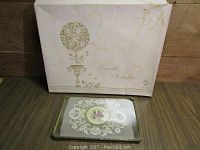 Original box with decorative linens for double bed and embellished footed tray shown stacked together