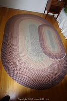 Three matching braided wool oval rugs displayed on hardwood floor showing color and pattern details.