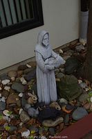 Full view of St. Francis statue surrounded by animals on rocks and leaves.