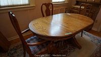 Full view of oak oval dining table with chairs