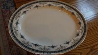White oval platter with blue and gold floral scroll pattern and gold trim