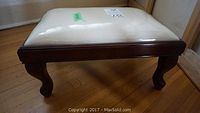 Wooden frame bench with white cushioned top on rounded legs