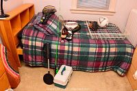 Photo showing full bed setup with badminton rackets, fishing rod, tackle box, fish finder, and soccer ball.