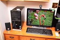 Full setup on desk showing tower, monitor, keyboard and speakers