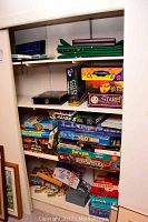 Photo showing multiple board games stacked on shelves including ThinkBlot, CSI, The Davinci Dilemma, Stare, Sky Runner, Password, Backgammon, Slide 5, Star Wars boxed games and others.