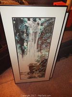 Two vertical framed art prints with waterfall scenes, showing overall condition and size.