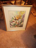 Framed floral print with colorful flowers, gold-tone frame, and white mat. Visible artist signature Tomlinson.
