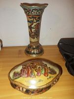 Two Asian themed ceramic pieces: a tall vase and a shell shaped trinket dish, both hand painted and detailed with textured patterns and gold accents.