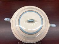 Top view of the closed lidded serving dish showing blue painted handles and blue band with gold trim.