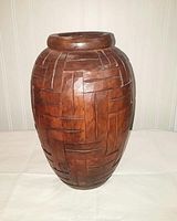 Front view of the carved wooden vase showing detailed geometric carving and smooth dark wood finish.
